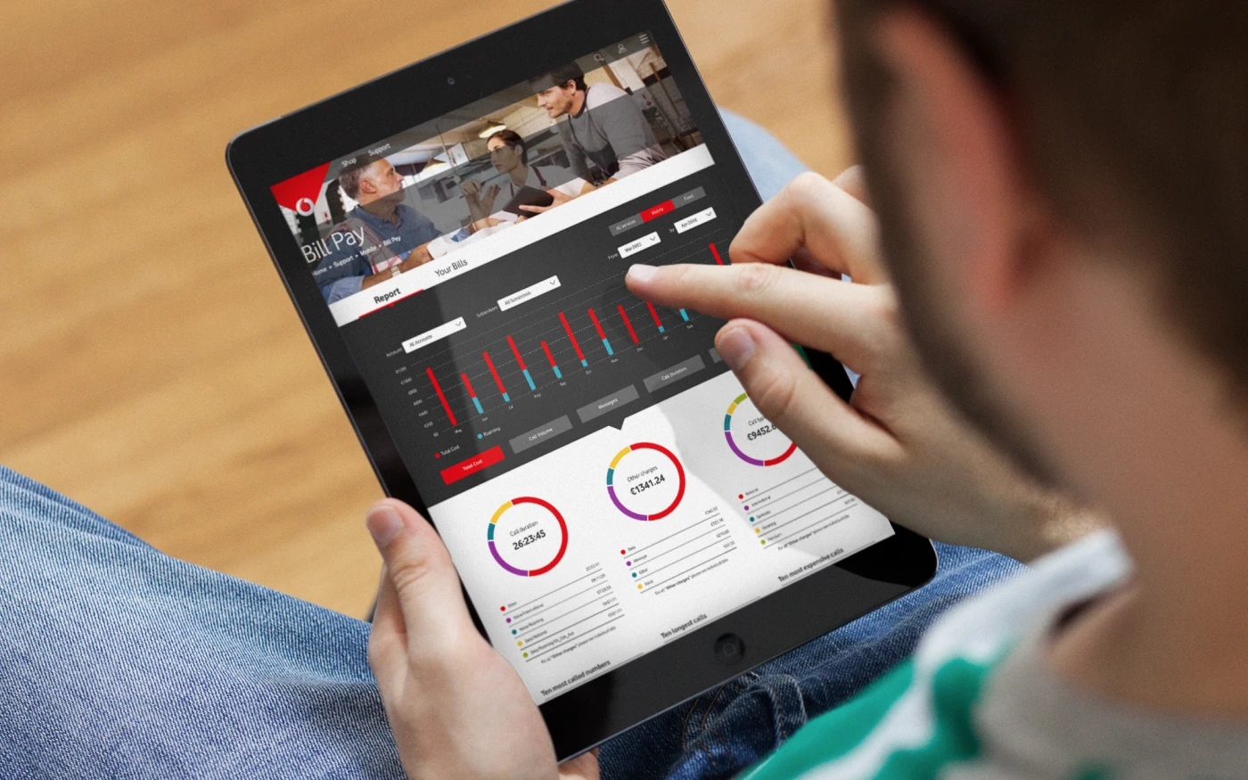 A customer reviewing the Vodafone bill-pay report on a tablet, with usage and charges broken down as bar and donut charts